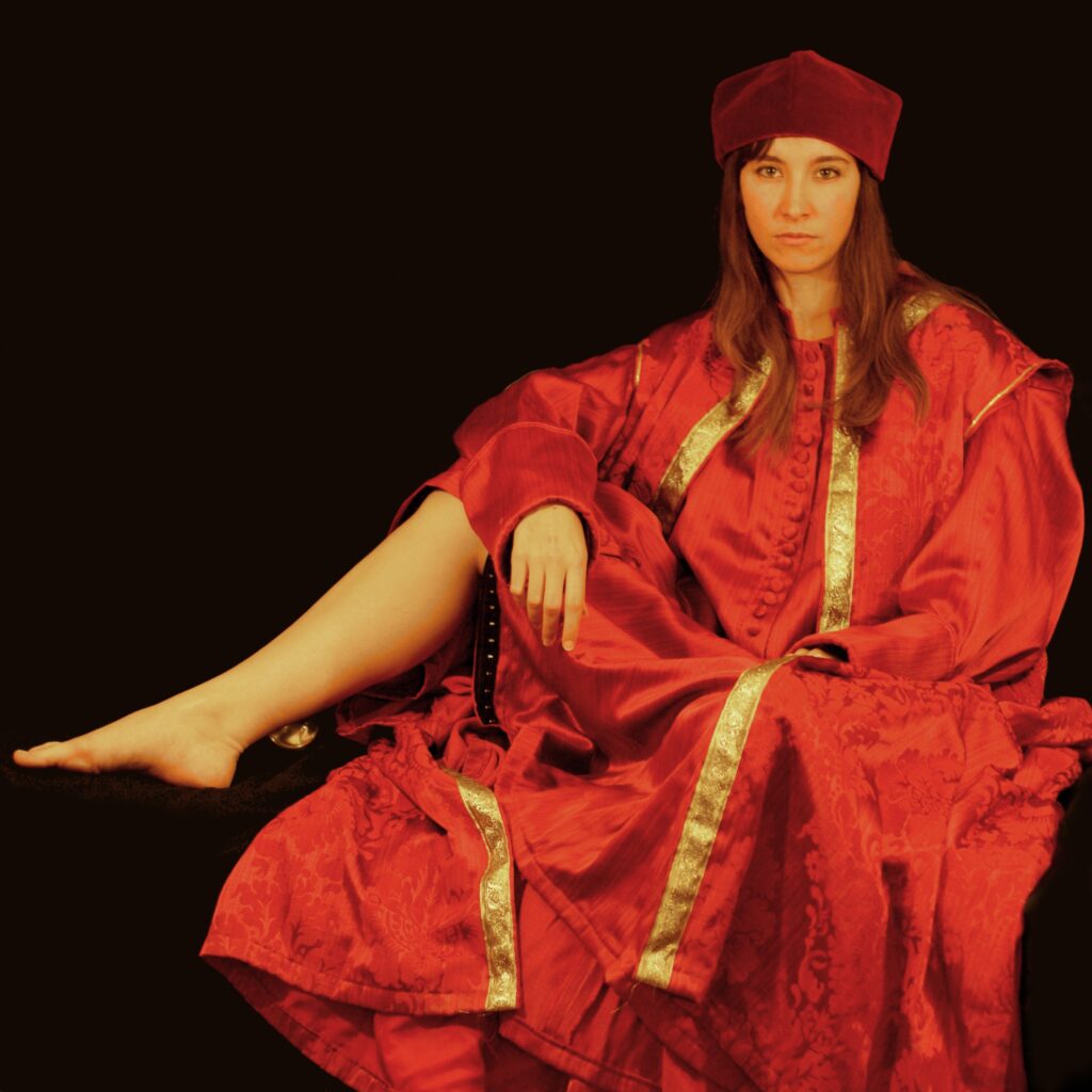 Photographie d'une femme assise portant une tenue de cardinal