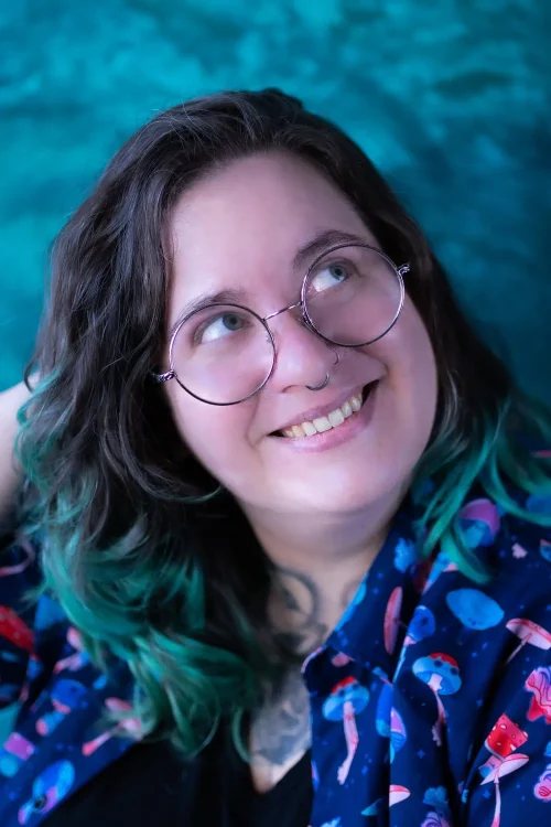 Portrait d'une personne souriante aux cheveux verts